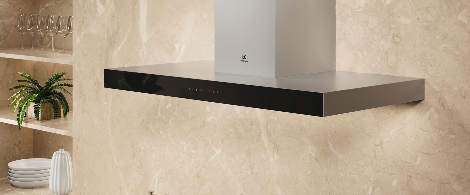 A silver cooker hood placed on a beige wall in a kitchen.